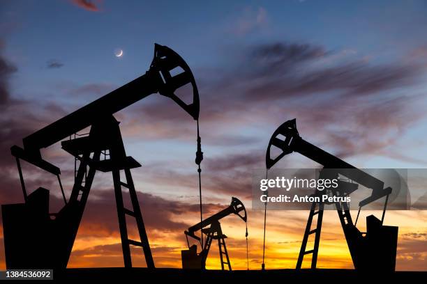 oil pump on a sunset background. world oil industry - perzische golfstaten stockfoto's en -beelden