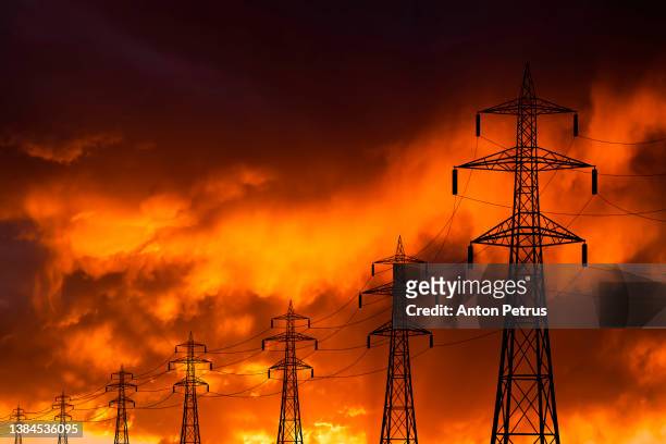 high voltage towers at sunset background. power lines against the sky - power grid stock pictures, royalty-free photos & images