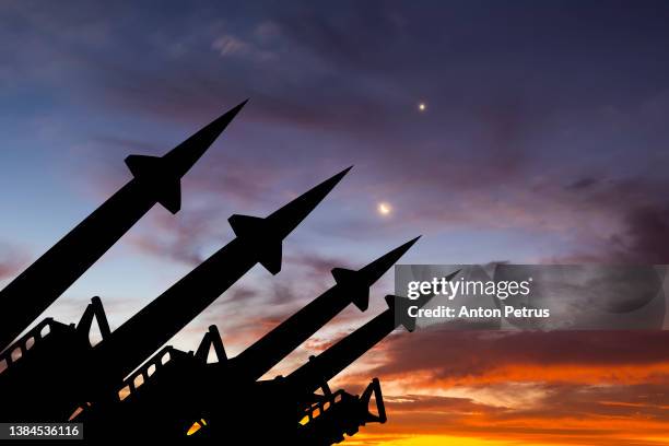 threat of nuclear war.  missile system on the background of sunset sky - war foto e immagini stock