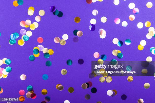 large multicolored confetti on a purple background - スパンコール ストックフォトと画像