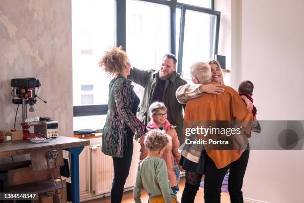 couple accueillant des invités pour une fête à la maison - vie sociale photos et images de collection