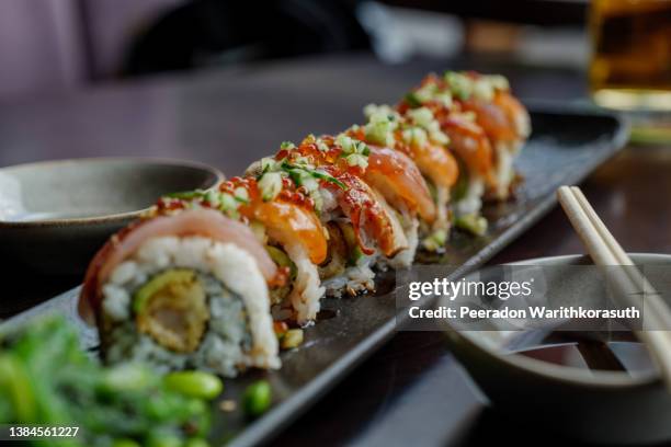 dragon roll, roll of sushi on top with fresh raw fish. - restaurant düsseldorf stock-fotos und bilder