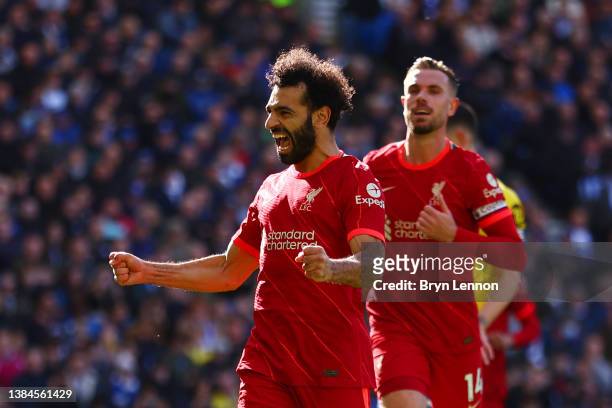 Mohamed Salah of Liverpool celebrates with teammate Jordan Henderson after scoring their team's second goal from the penalty spot during the Premier...
