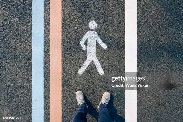 a pair of feet standing on a pedestrian road - traffic free stockfoto's en -beelden