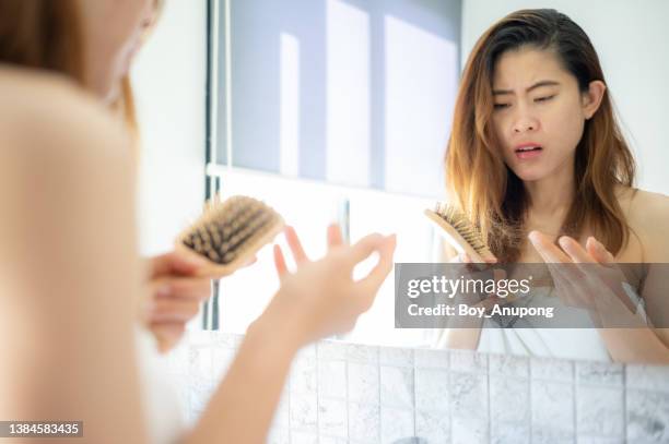 asian woman having negative emotion after her hair fall while brushing. - hair stock pictures, royalty-free photos & images