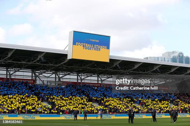 Screen displays the message "Football Stands Together" featuring a Ukrainian flag inside the stadium to indicate peace and sympathy with Ukraine...