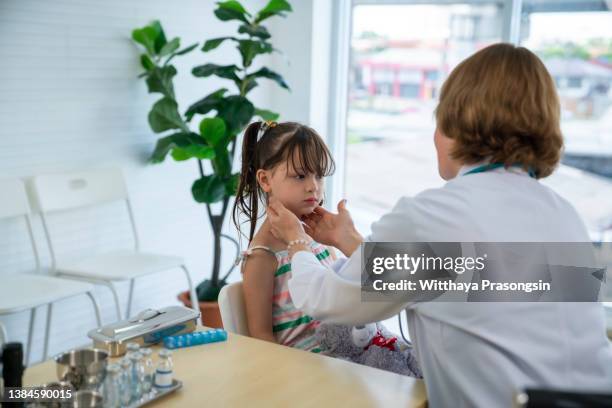 doctor checking tonsils of patient at hospital - tonsille stock-fotos und bilder