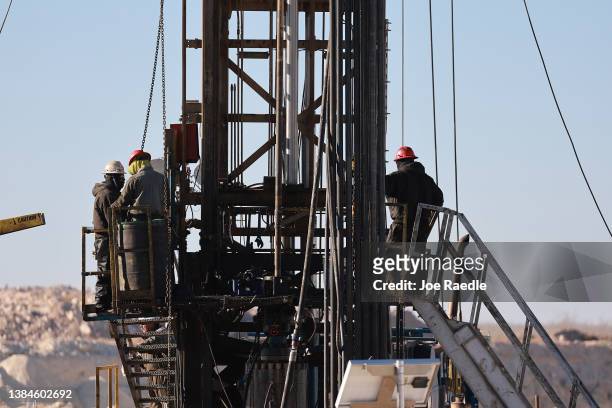 Workers place pipe into the ground on an oil drilling rig set up in the Permian Basin oil field on March 12, 2022 in Midland, Texas. President Joe...