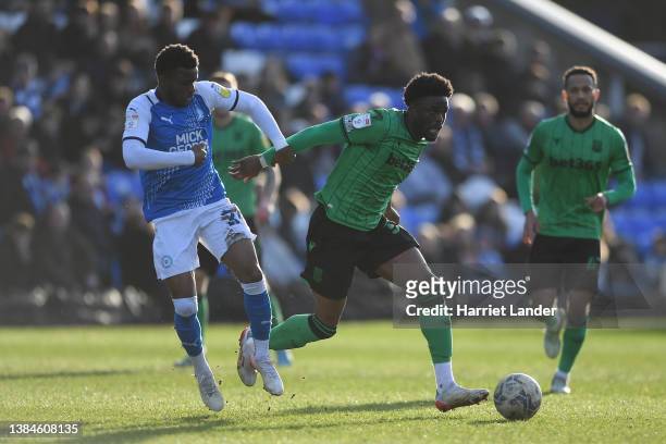 Josh Maja of Stoke City is challenged by Bali Mumba of Peterborough United during the Sky Bet Championship match between Peterborough United and...