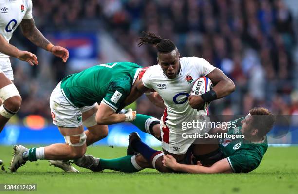 Maro Itoje of England is tackled by Josh van der Flier and Iain Henderson of Ireland during the Guinness Six Nations Rugby match between England and...