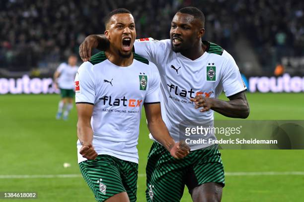Alassane Plea of Borussia Moenchengladbach celebrates with teammate Marcus Thuram after scoring their team's first goal from a penalty during the...
