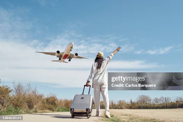 rear photo of woman - luggage trolley stockfoto's en -beelden