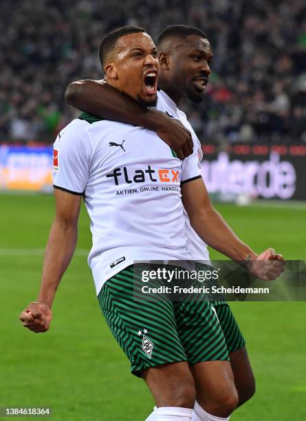 Alassane Plea of Borussia Moenchengladbach celebrates with teammate Marcus Thuram after scoring their team's first goal from a penalty during the...