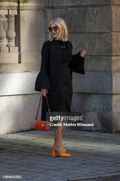 Petra Dieners is seen wearing Puretoi by Petra Dieners coat, silk blouse and skirt, Bottega Veneta shoes, Dior Handbag on March 10, 2022 in...
