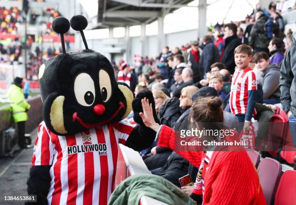 Brentford Mascot Buzz Bee high fives the fans ahead of the Premier League match between Brentford and Burnley at Brentford Community Stadium on March...