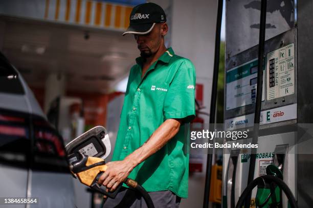 Petrobras employee fills the gas tank of a client at a Petrobras gas station near the Santos Dumont airport on March 12, 2022 in Rio de Janeiro,...