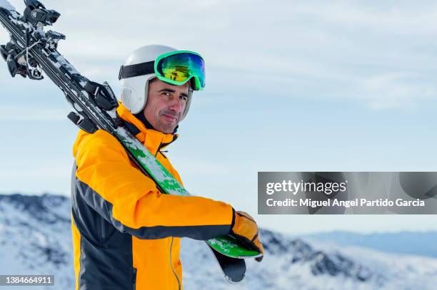 smiling man carrying his skis and looking at the camera - sierra nevada spain ski photos et images de collection