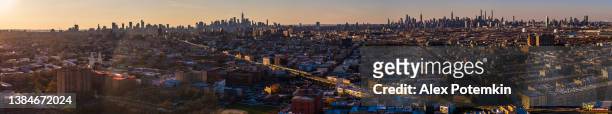 brooklyn's residential areas with the distant manhattan skyline, from lower manhattan and downtown to midtown and uptown in the backdrop, at sunset.  extra-large, high-resolution stitched panorama. - skyline stitched composition stock pictures, royalty-free photos & images