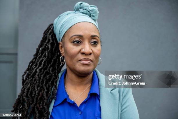 mature black businesswoman against gray background - blå blus bildbanksfoton och bilder