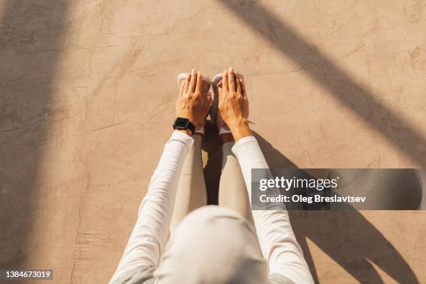 woman stretching legs and back. unrecognisable person, sports concept with background for copy space - hijab feet stockfoto's en -beelden