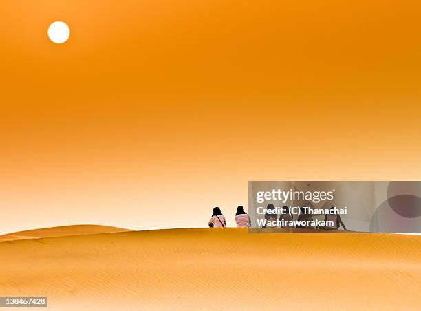 tourists on dune ii comtemplating sunrise - merzouga stock pictures, royalty-free photos & images