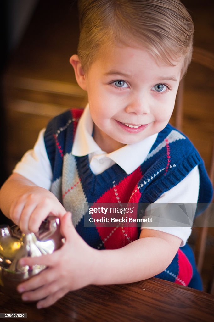 Boy smiling and thinking about opening piggy bank