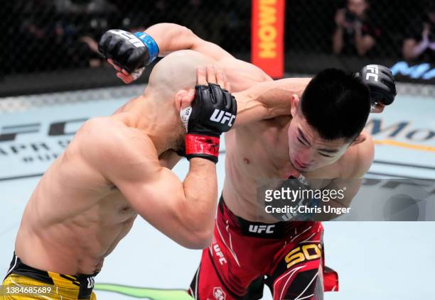 Song Yadong of China and Marlon Moraes of Brazil trade punches in their bantamweight fight during the UFC Fight Night event at UFC APEX on March 12,...
