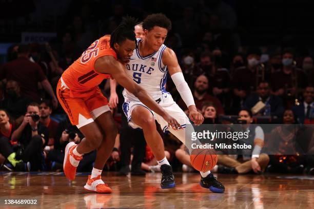 Paolo Banchero of the Duke Blue Devils and Justyn Mutts of the Virginia Tech Hokies pursue the loose ball during the 2022 Men's ACC Basketball...