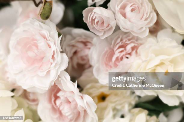 background of artificial pink rose blooms - zachtroze stockfoto's en -beelden