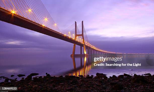 vasco da gama bridge in lisbon at dawn - vasco da gama bridge stock pictures, royalty-free photos & images