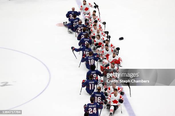 Team United States shakes hands with Team Canada after winning the gold medal during the Para Ice Hockey Gold Medal game on day nine of the Beijing...