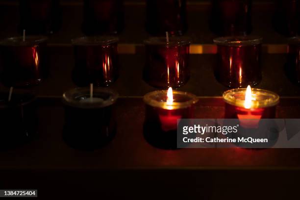 illuminated prayer candles - mourning candles stock pictures, royalty-free photos & images