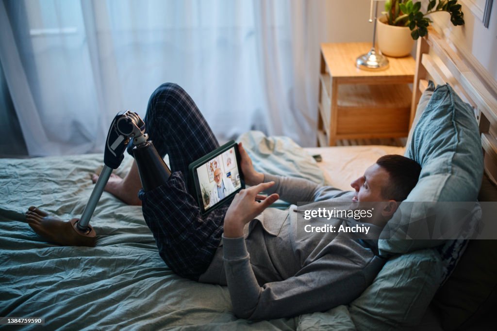 Disabled young man with prosthetic leg having online mental health session