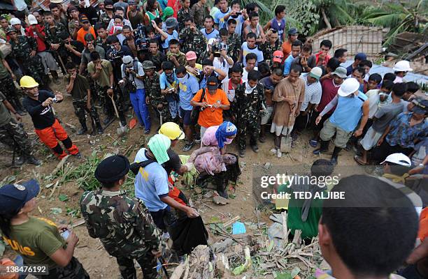 Recuers carry the dead body of a 21-year-old female, retrieved from a mountain slope after it collapsed at the height of the earthquake in the...
