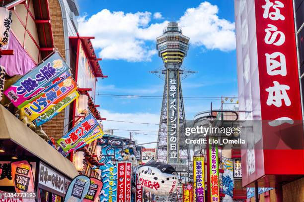 osaka tower and view of the neon advertisements in shinsekai district, osaka - kinki stockfoto's en -beelden