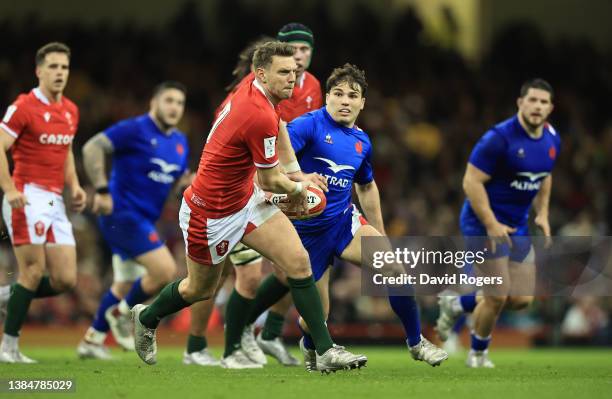 Dan Biggar of Wales passes the ball watched by Antoine Dupont during the Guinness Six Nations Rugby match between Wales and France at the...