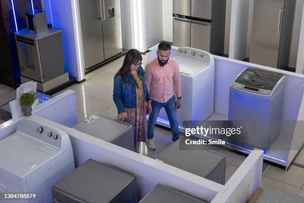 couple choosing washing machine - appliance shop stock pictures, royalty-free photos & images