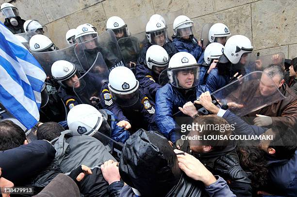 Protesters clash with riot police while they try to enter the parliament during a 24-hours general strike in Athens on February 7, 2012. A general...