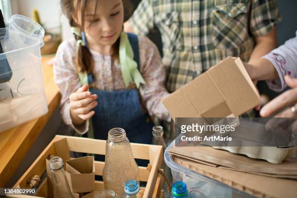 family  sorting out waste for recycling - help:category stock pictures, royalty-free photos & images