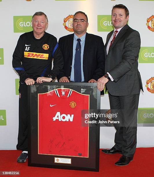 Sir Alex Ferguson and Commercial Director Richard Arnold of Manchester United present a signed shirt to Haris Kotsibos, CEO of Globul, after a press...