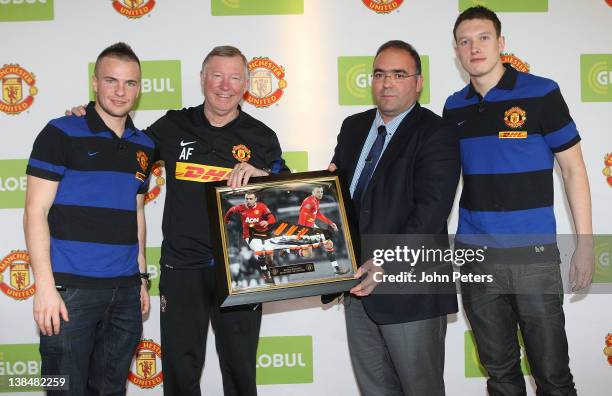 Tom Cleverly , Sir Alex Ferguson and Phil Jones of Manchester United present a signed Dimitar Berbatov boot to Haris Kotsibos, CEO of Globul, after a...