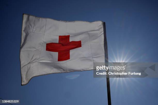 The flag of the International Red Cross flies as efugees fleeing Ukraine arrive at the Vysne Nemecke border crossing on March 13, 2022 in Vysne...