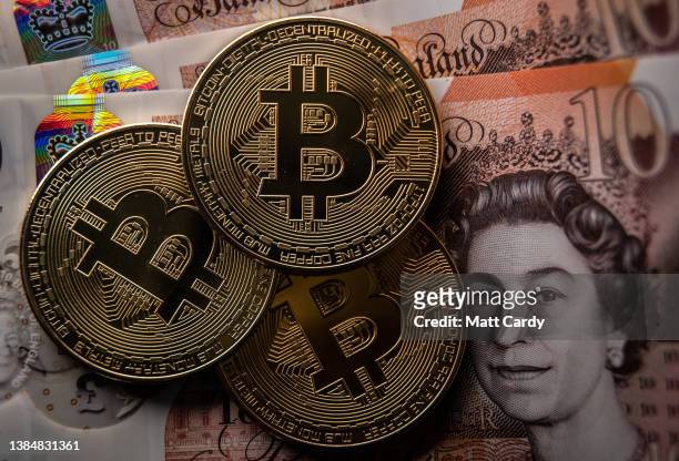 In this photo illustration a novelty Bitcoin token is photographed on a Sterling British Pound GBP bank note, on March 13, 2022 in Bristol, England....