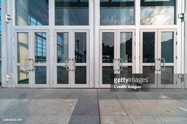 closed metal glass door in sunlight - sliding door photos et images de collection