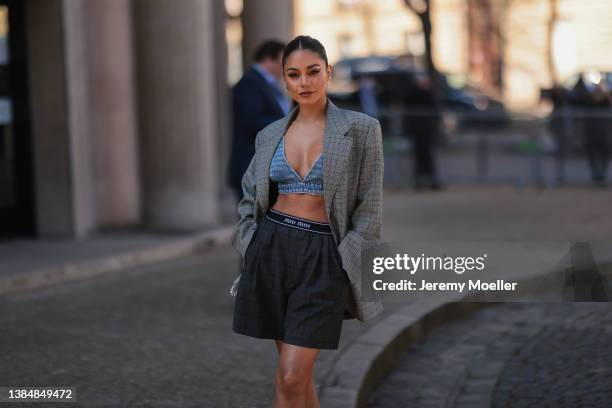 Vanessa Hudgens seen wearing gold earrings, a grey checkered oversize blazer, a denim crop top from Miu Miu, black plateau heels and a dark grey...