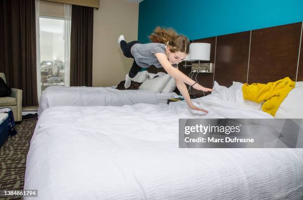 girl jumping on beds in hotel room - diving to the ground bildbanksfoton och bilder