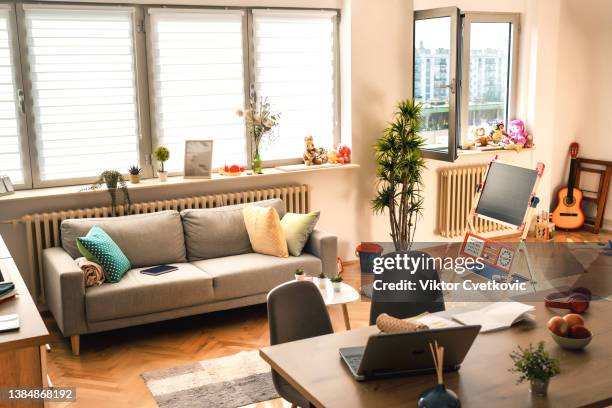 shot of a living room interior with hardwood floors and windows - messy living room stock pictures, royalty-free photos & images