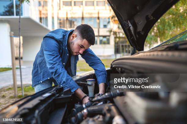 young man fixing his car engine - car repair stock pictures, royalty-free photos & images
