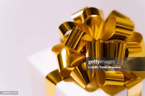 abstract gift box with golden metallic ribbon bow close-up - lint strik stockfoto's en -beelden