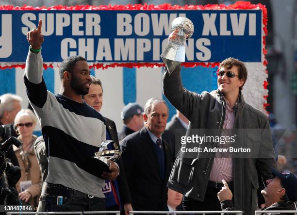 Quarterback Eli Manning of the New York Giants and Super Bowl XLVI MVP holds the Vince Lombardi Trophy as Justin Tuck of the New York Giants looks on...